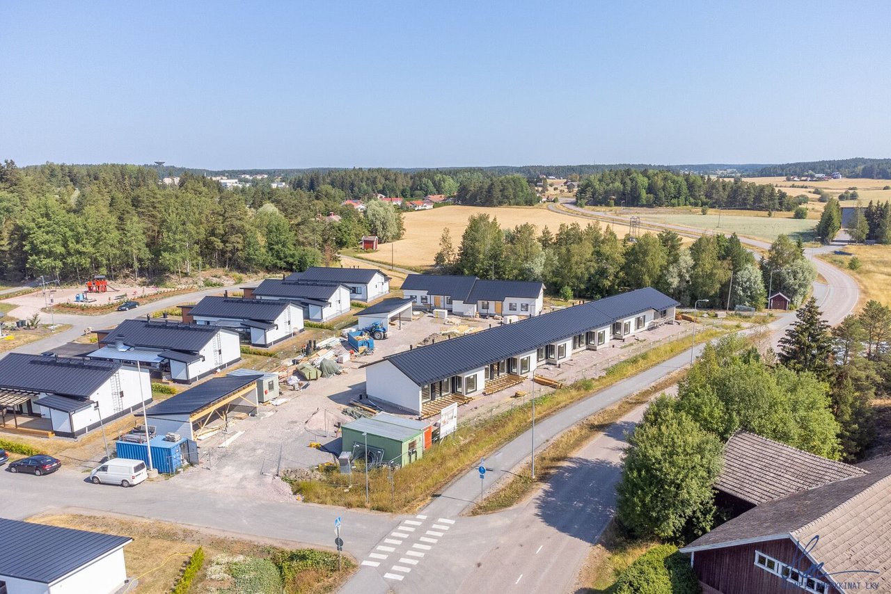 Ilmakuva Liedon Vihersiipiaran rakenteilla olevista rivi- ja paritaloista peltojen ja metsän keskellä.